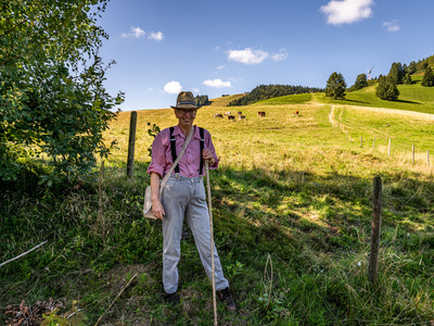 Auf dem Foto ist Dorfhirte Otto zu sehen. Im Hintergrund die Berglandschaft von Fröhnd sowie einige Hinterwälder Rinder. Auf dem Foto ist Dorfhirte Otto zu sehen. Im Hintergrund die Berglandschaft von Fröhnd sowie einige Hinterwälder Rinder.